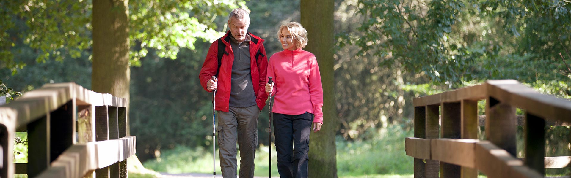 Man and woman on hiking trail with a bridge.